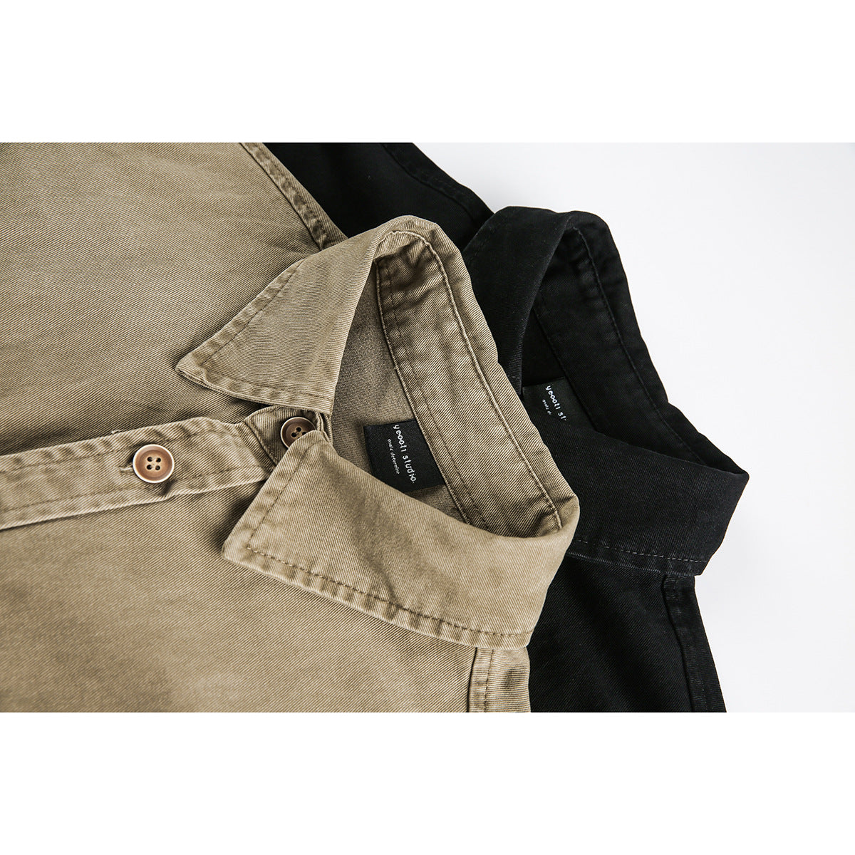 Close-up of tan and black button-up shirts showing their collars, buttons, stitching, and sewn neck labels.