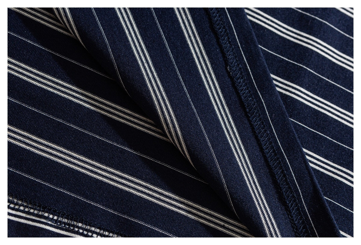 Close-up of navy fabric with narrow white stripes, folds, and a visible overlocked seam.