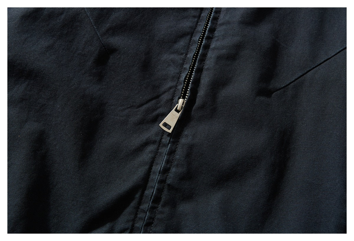 Close-up of a black garment's metal zipper and surrounding seams.