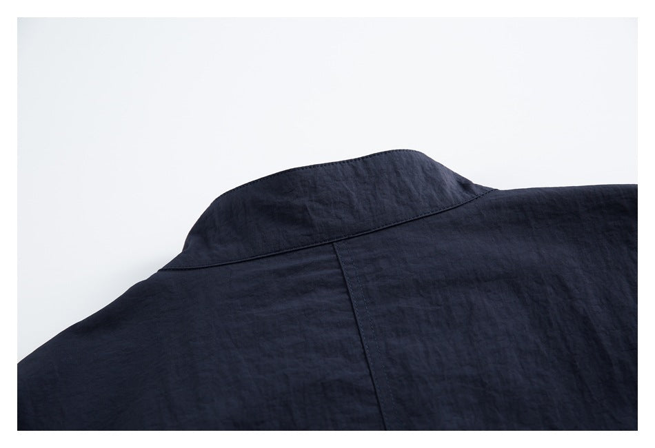 Close-up of the solid navy shirt back and collar seam.