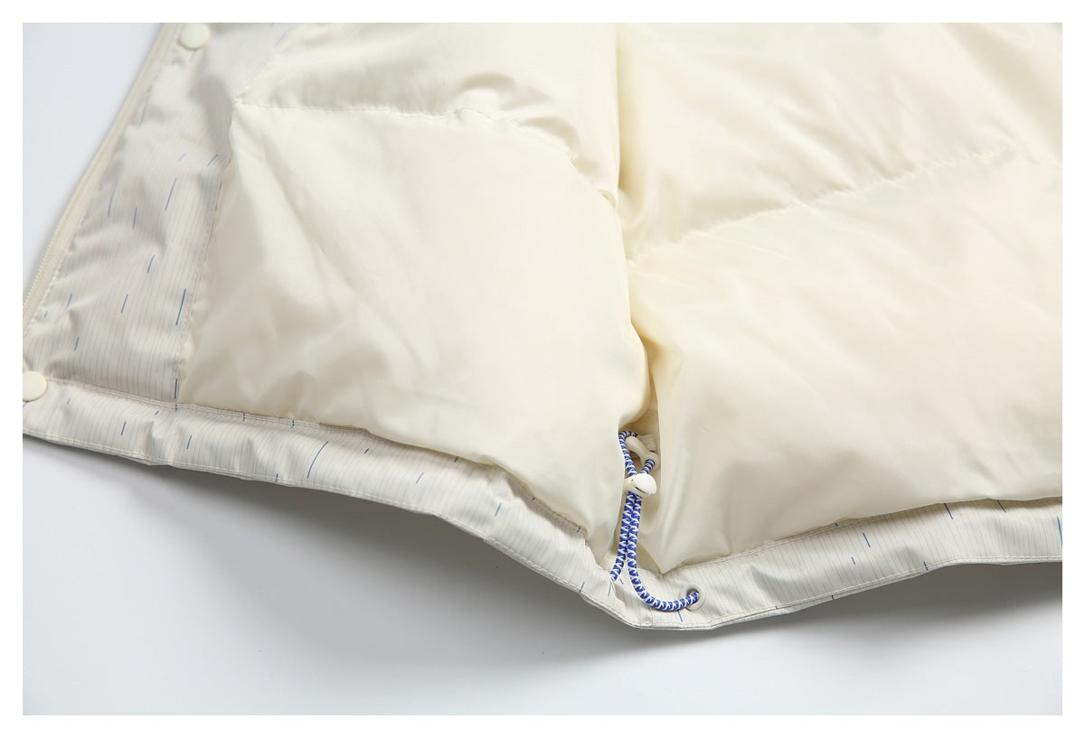 Close-up of a cream jacket interior, showing the lining, hem, snaps, and blue-and-white drawcord.