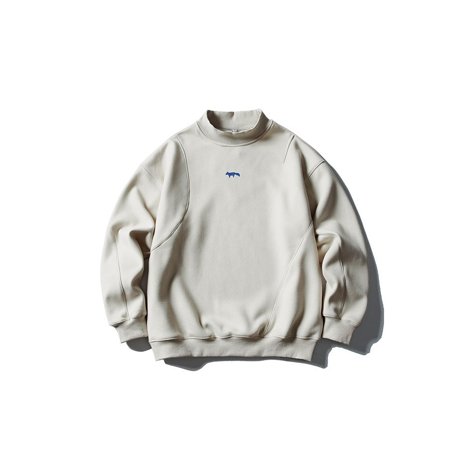 Beige mock-neck pullover sweatshirt with curved seams and small blue fox logo, flat lay front view