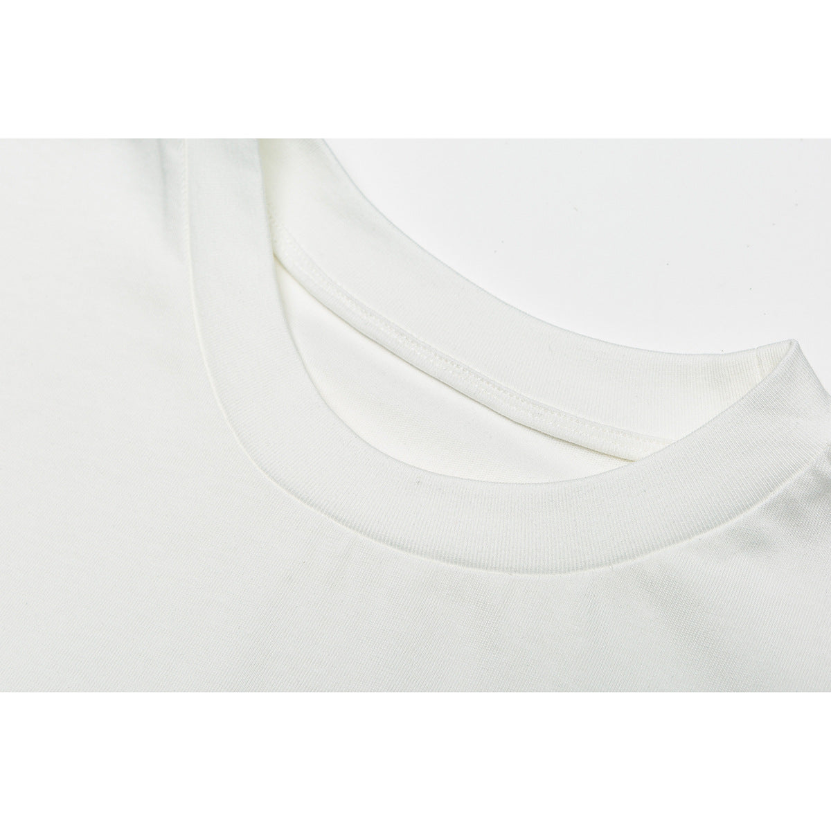 Close-up of a white T-shirt's ribbed crew neckline and collar stitching.
