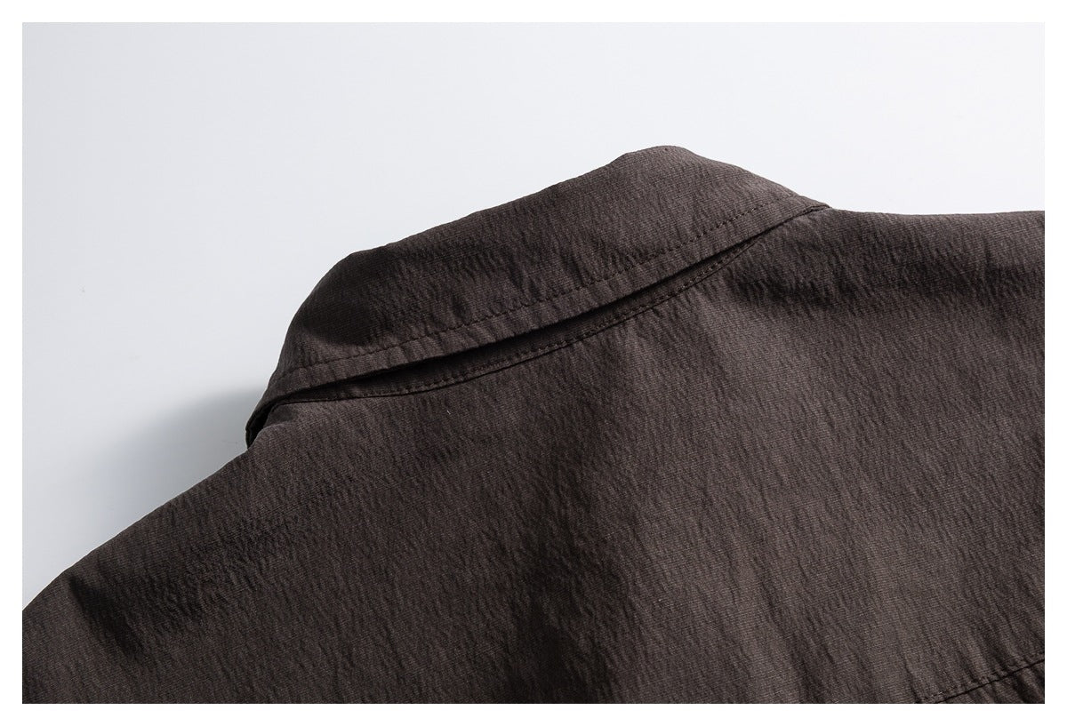 Close-up of the back collar and shoulder seam on a dark brown shirt.