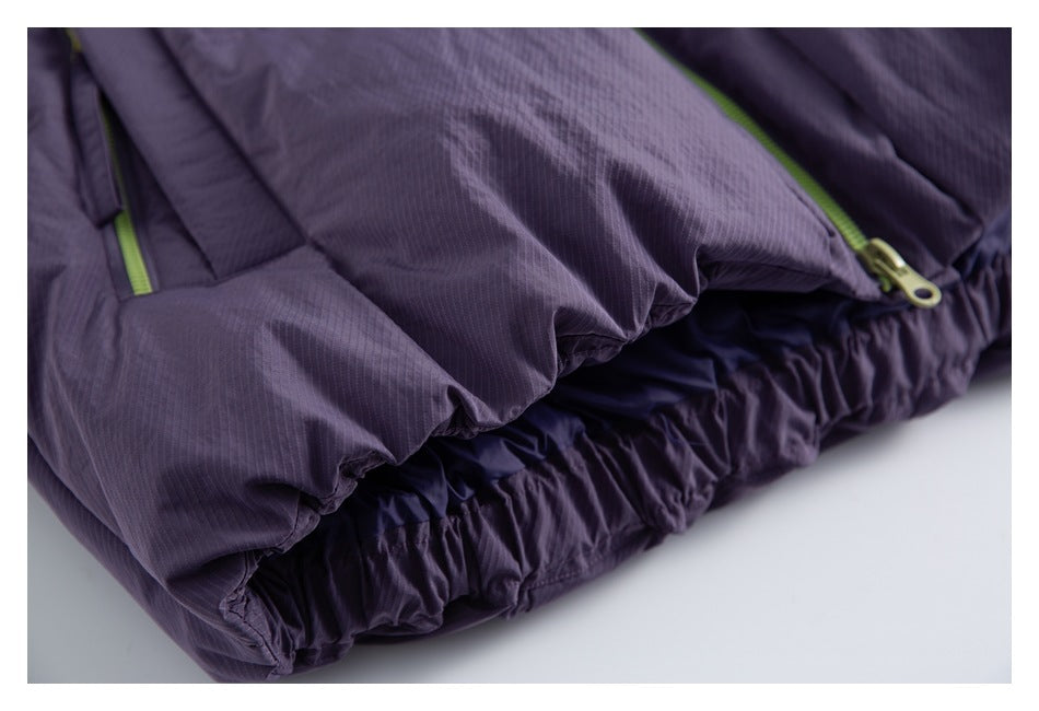 Close-up of a dark purple garment's gathered hem and pocket area with lime-green zipper pulls.