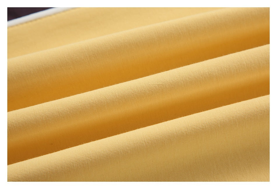 Macro view of pale yellow garment fabric folded into parallel ridges.