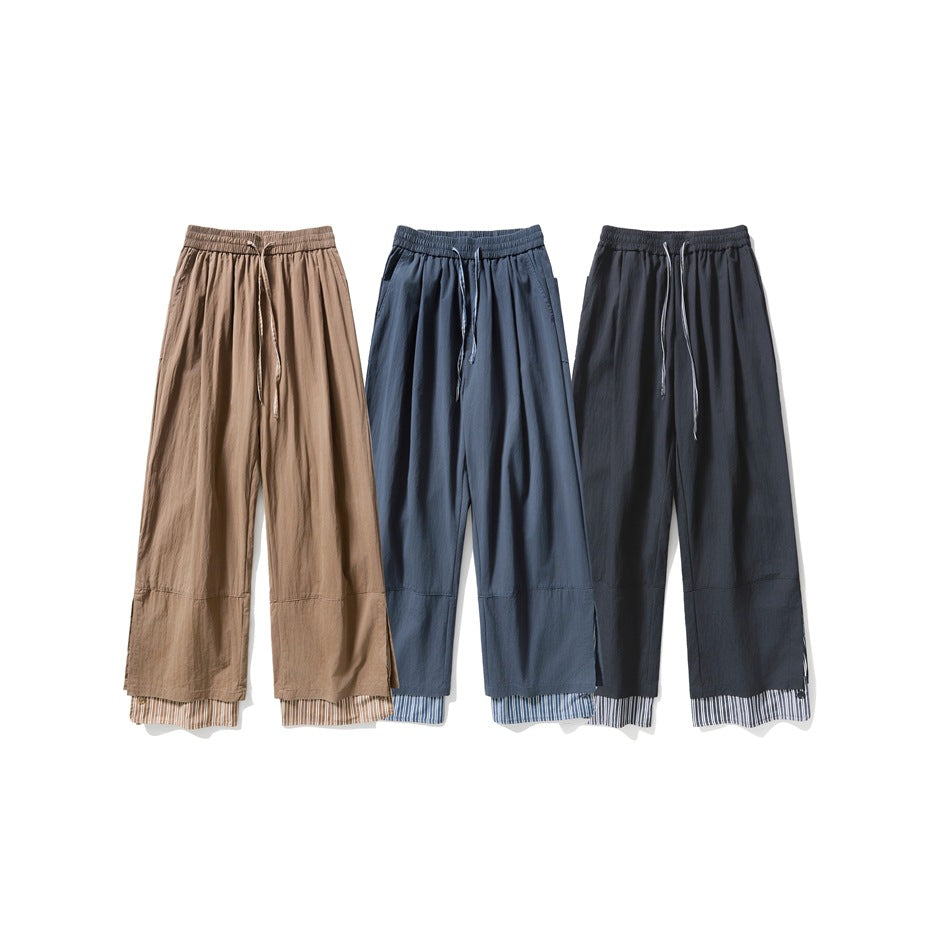 Three pairs of wide-leg drawstring trousers in taupe, slate blue, and charcoal, with striped fabric peeking at the hems.