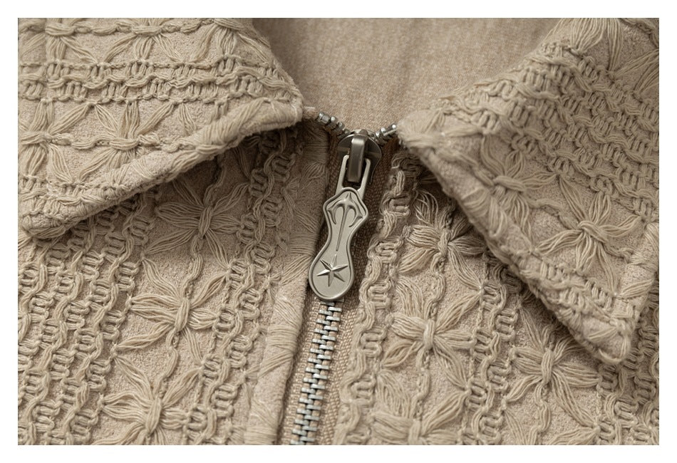 Extreme close-up of the jacket's metal zipper pull and raised beige woven texture.