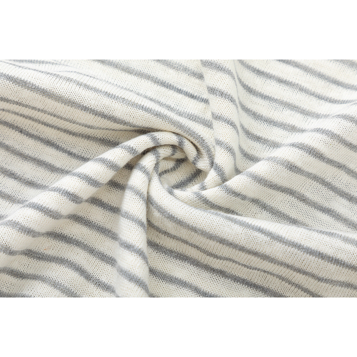 Close-up of cream knit fabric with narrow gray stripes, gathered into folds to show its texture.