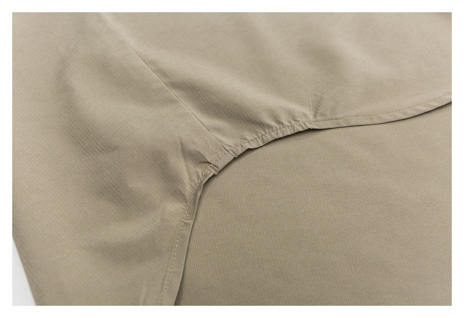 Close-up of a beige garment seam where a curved panel joins the body.