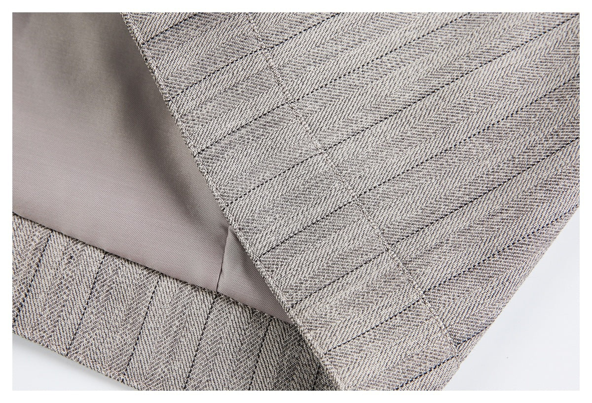 Inside view showing smooth gray lining beside the edge of gray-beige patterned fabric.
