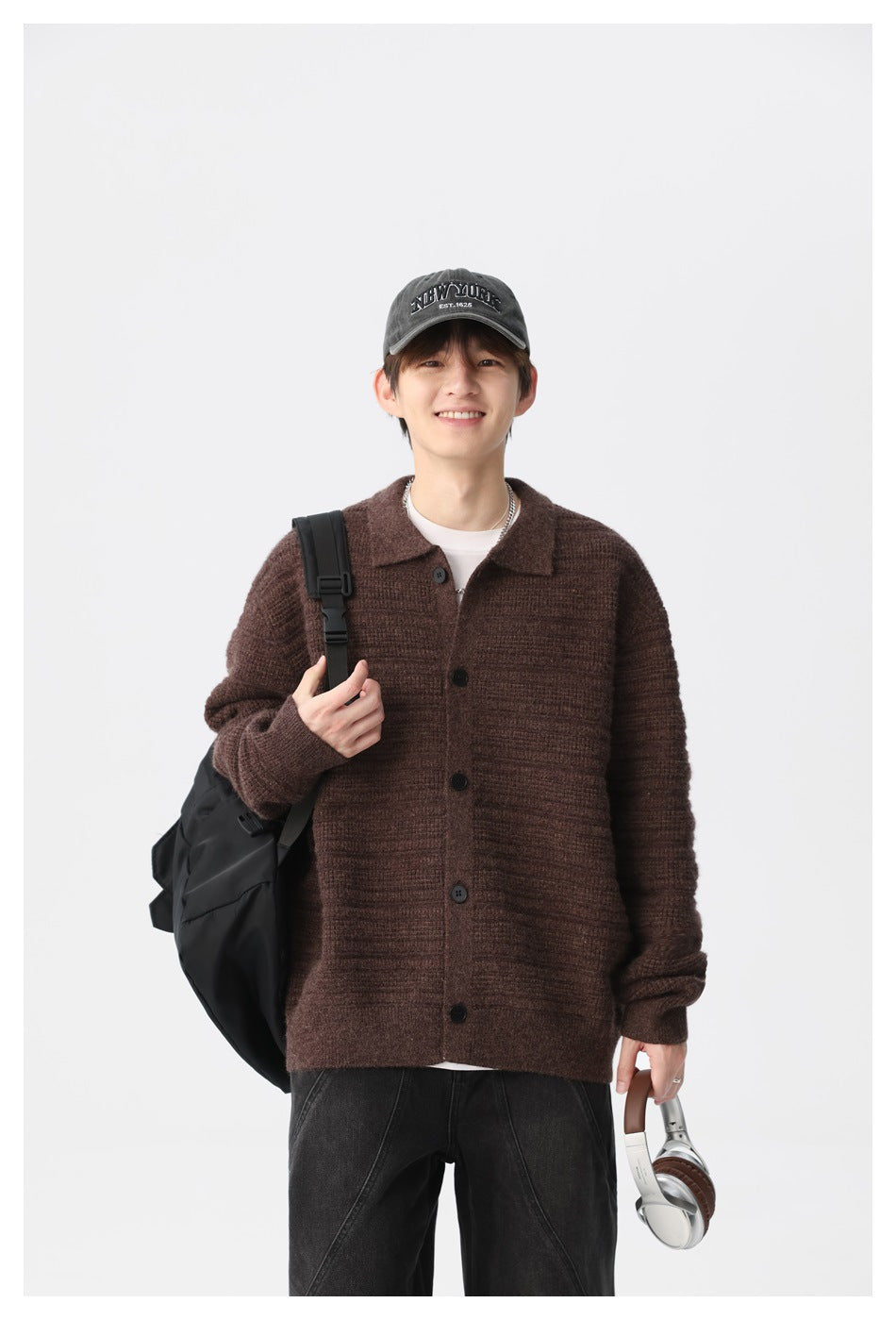 Model wearing a dark brown ribbed cardigan with a collar and buttons, styled with a black backpack.