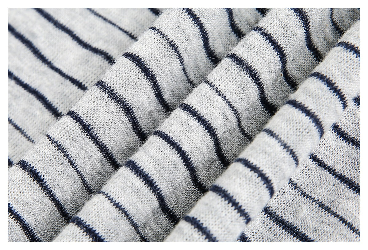 Close-up of folded light gray knit fabric with thin navy stripes, showing its texture.
