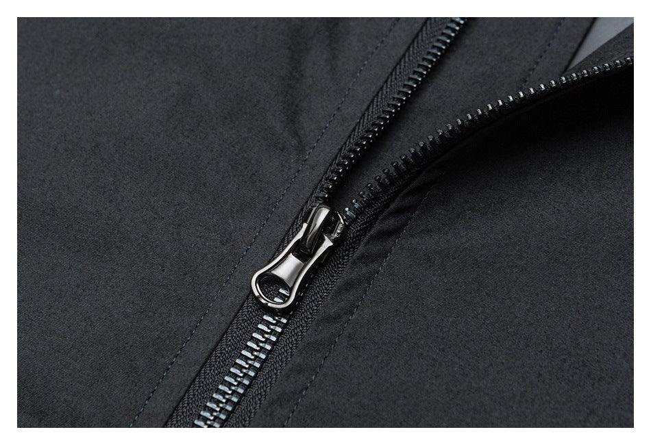 Close-up of a dark garment's diagonal zipper with a shiny metal pull.