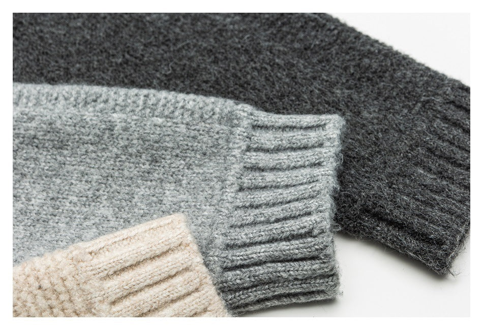 Close-up of ribbed sweater cuffs in charcoal, light gray, and cream knit.