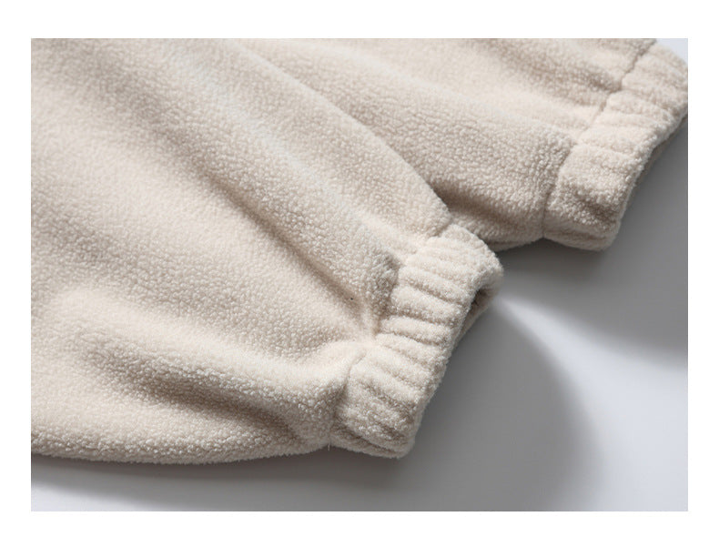 Close-up of gathered elastic cuffs on ivory plush fabric.
