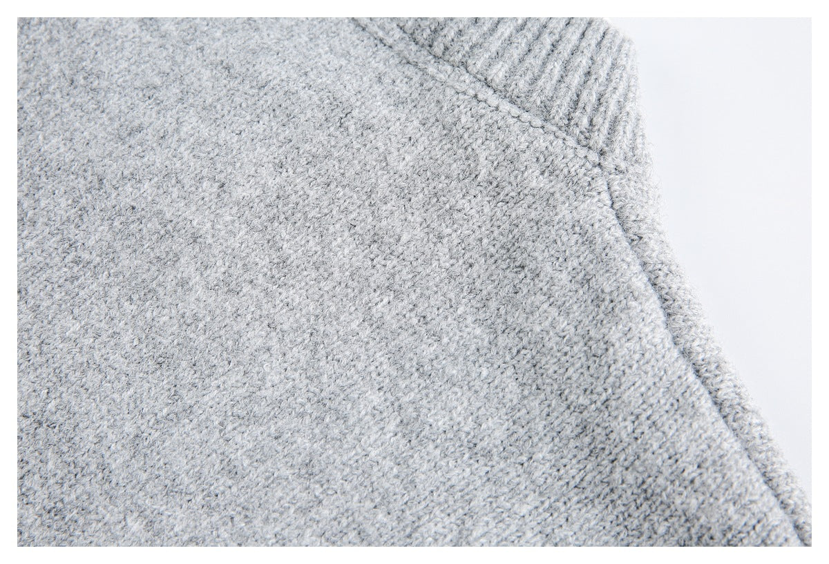 Close-up of light gray knit fabric with a ribbed edge and curved seam.