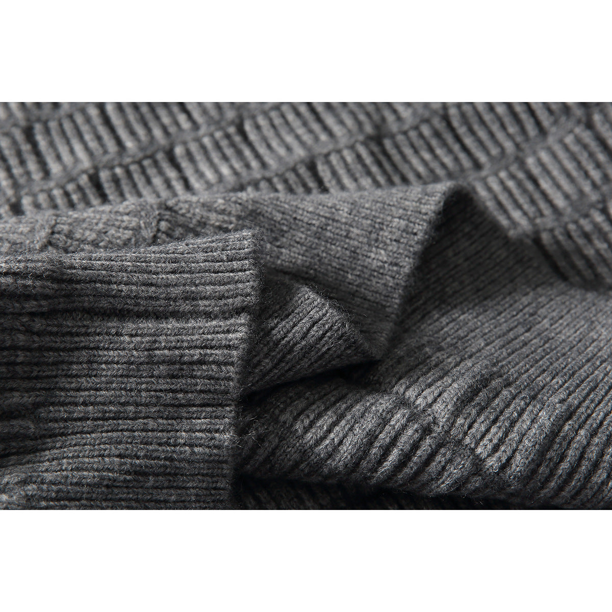 Close-up of gray knit fabric and ribbed sweater sections, highlighting the textured stitches.
