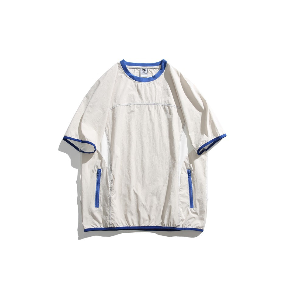 White short-sleeve crew neck top with blue trim, blue zippered side pockets and contrast topstitching, flat lay