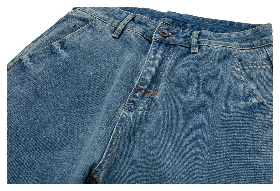 Close-up of blue jeans showing the front waistband, button, pockets and fly.