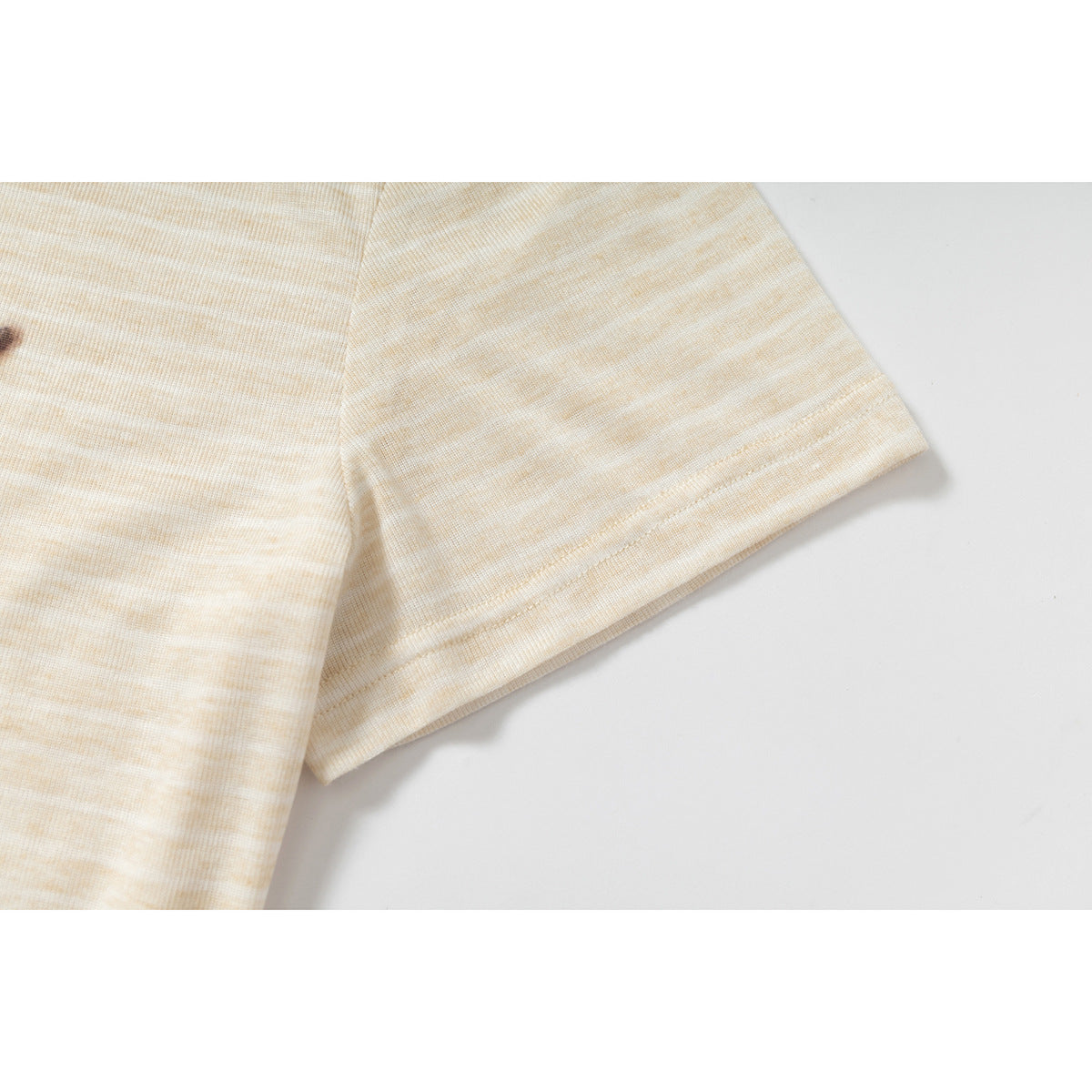 Close-up of the short sleeve and stitched hem on a light beige, subtly striped T-shirt.