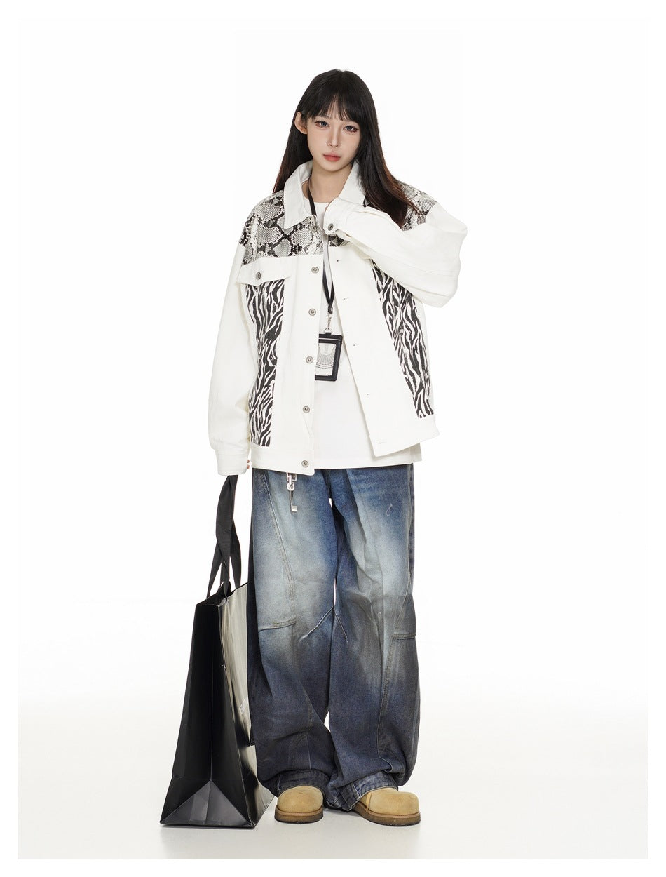 Model wearing the white snake and zebra print jacket over a white tee with wide-leg faded jeans, holding a black tote bag