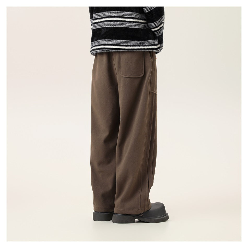 Rear three-quarter view of a model wearing loose brown cargo pants with large pockets.