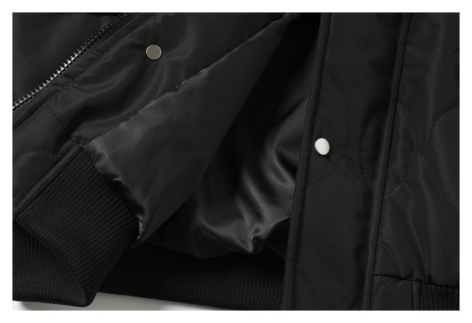 Close-up of the black jacket opened to show its smooth inner lining, zipper, snaps, and ribbed hem.