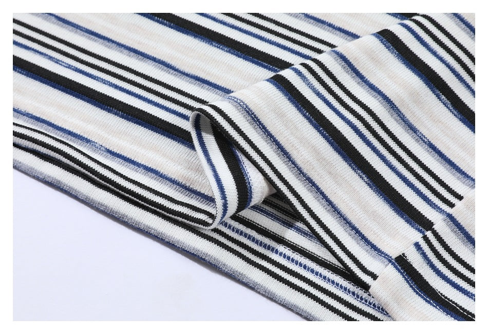 Close-up of the striped shirt's stitched hem and fabric edge, turned back to show the seam.