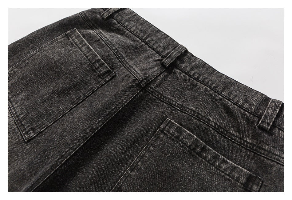 Close-up of the back of charcoal washed jeans, showing the waistband, belt loops, seams, and pockets.