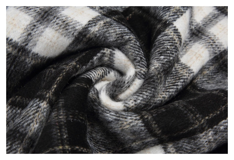 Close-up showing the soft-looking surface and plaid pattern of twisted black, gray, and cream fabric.