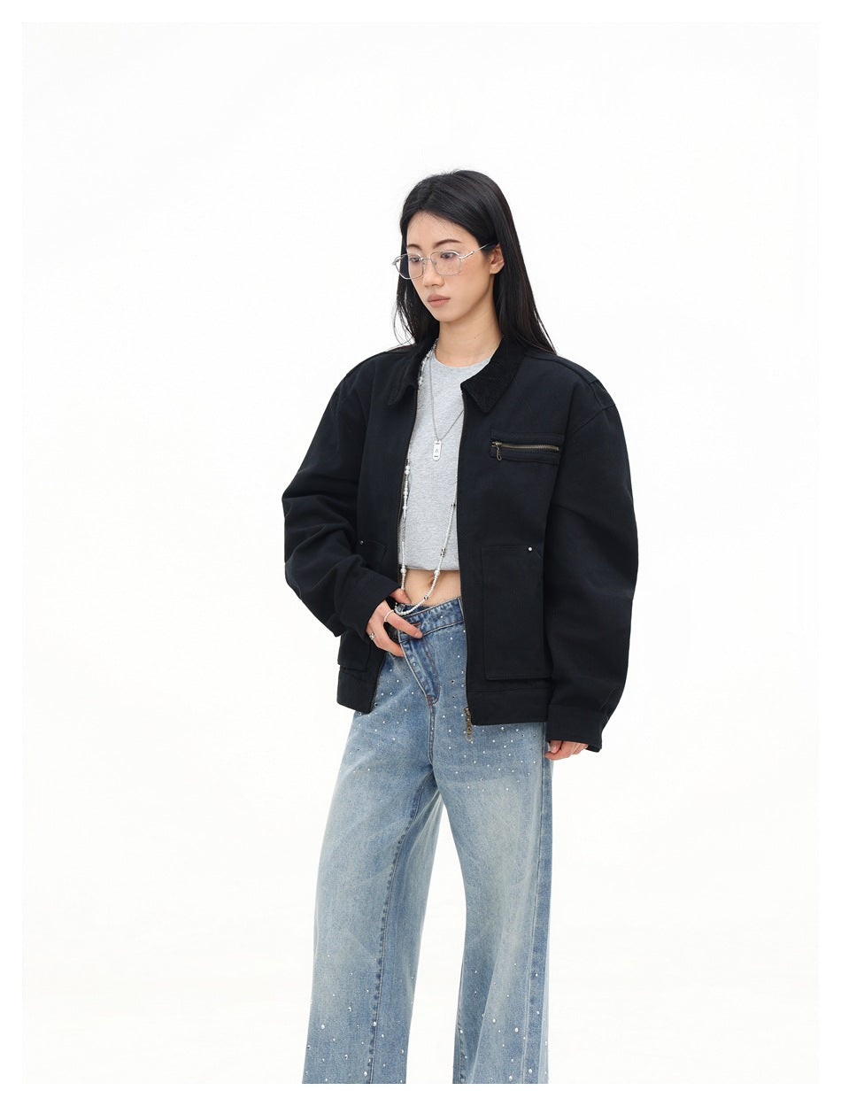 Three-quarter view of a model in an open black oversized jacket with a zip chest pocket and front patch pockets.
