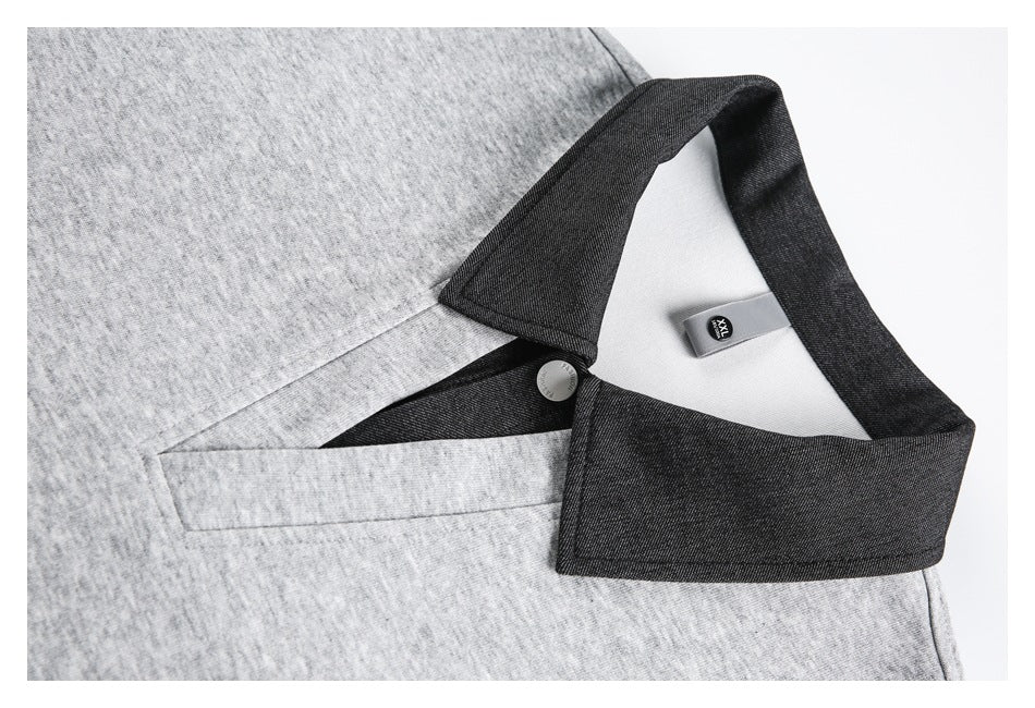 Close-up of the gray polo's dark collar, button, and V-shaped placket opening.