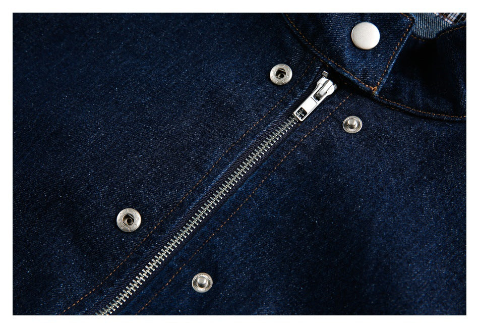 Close-up of the dark denim jacket's silver zipper and snap fasteners with contrast stitching.
