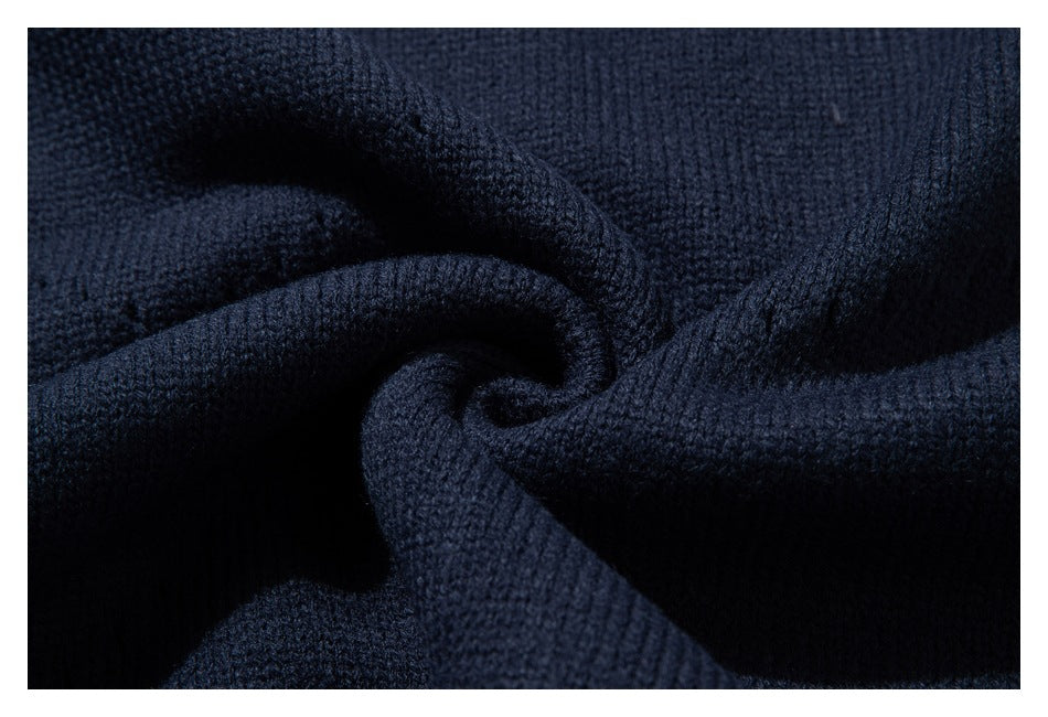 Close-up of dark navy knit sweater fabric gathered into soft folds.