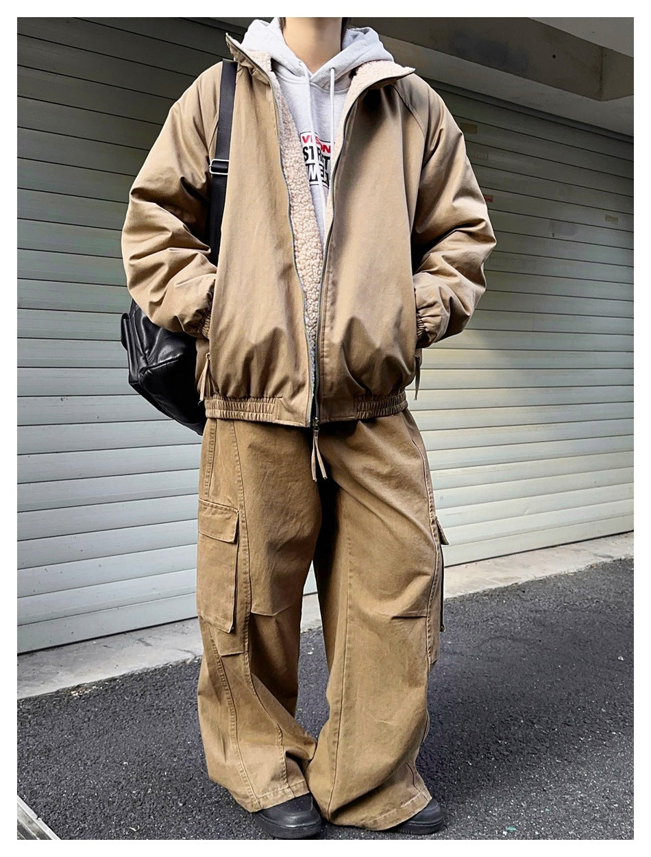 Model wearing a tan zip jacket with cream fleece lining over a gray hoodie and matching wide-leg cargo pants.