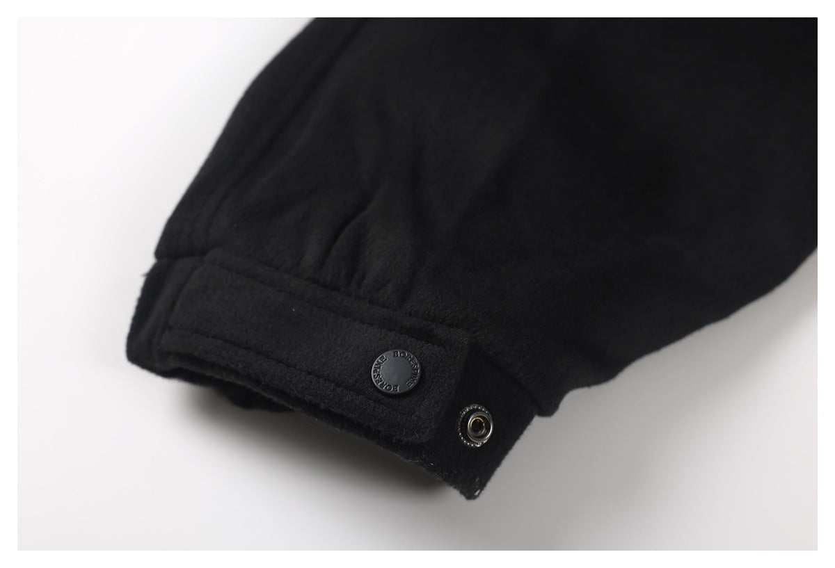 Close-up of a black jacket sleeve cuff with a branded snap button and metal fastener.