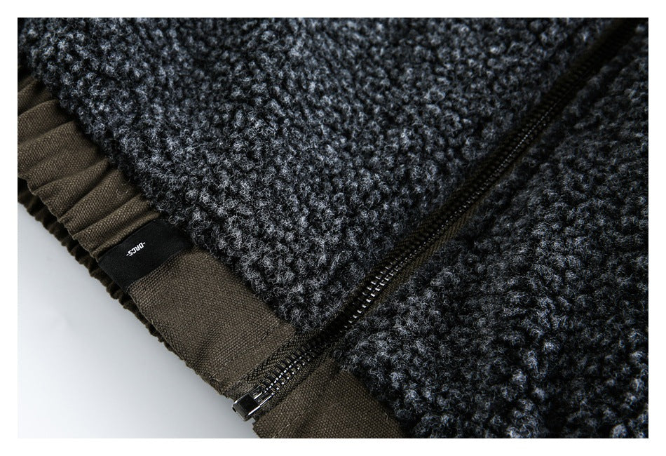 Close-up of a dark charcoal textured garment showing a black zipper, brown trim, and a small black label.