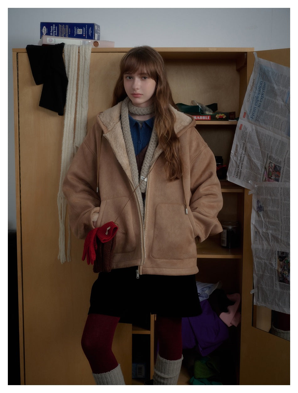 Model wearing a tan hooded zip coat with cream lining, layered over a blue shirt and scarf.