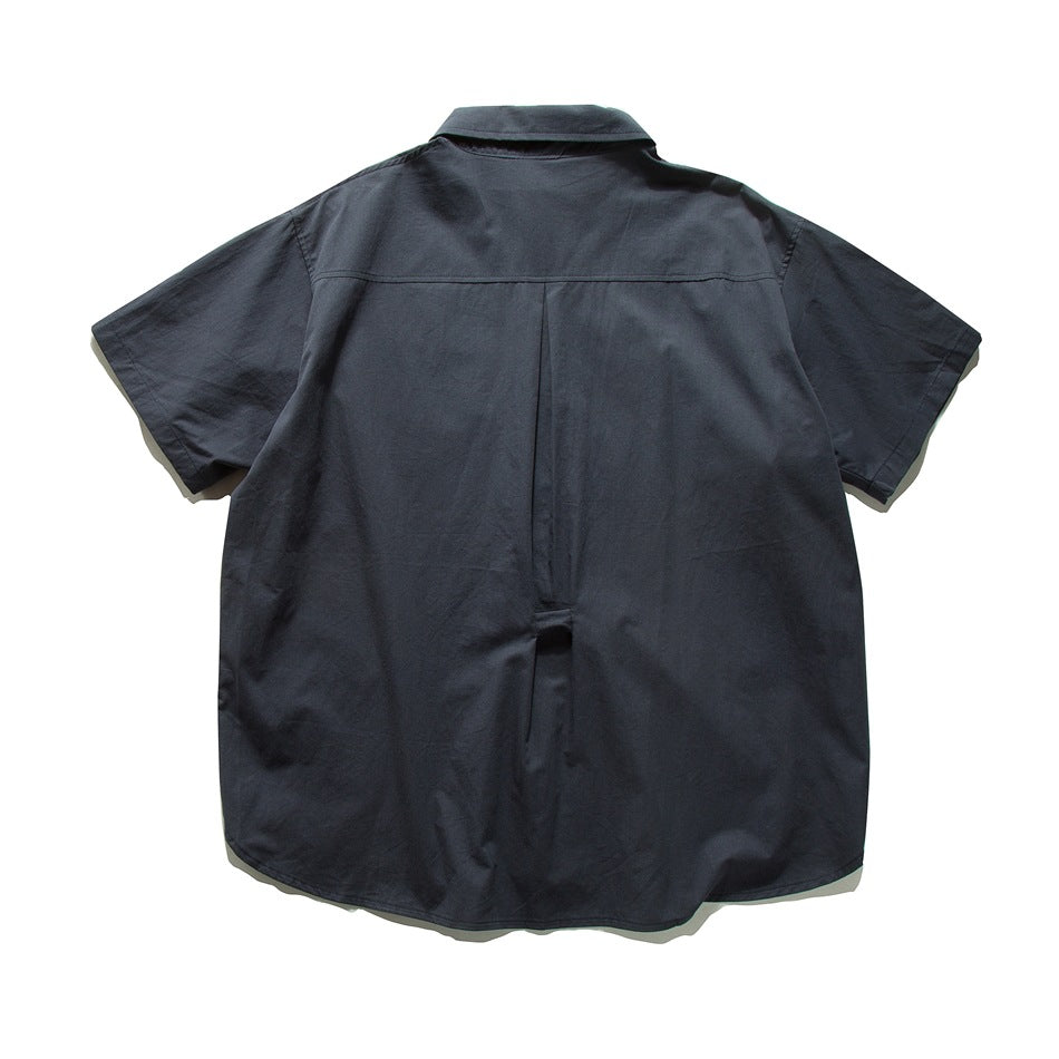 Back view of a dark navy short-sleeve button-up shirt with a collar and center pleat.