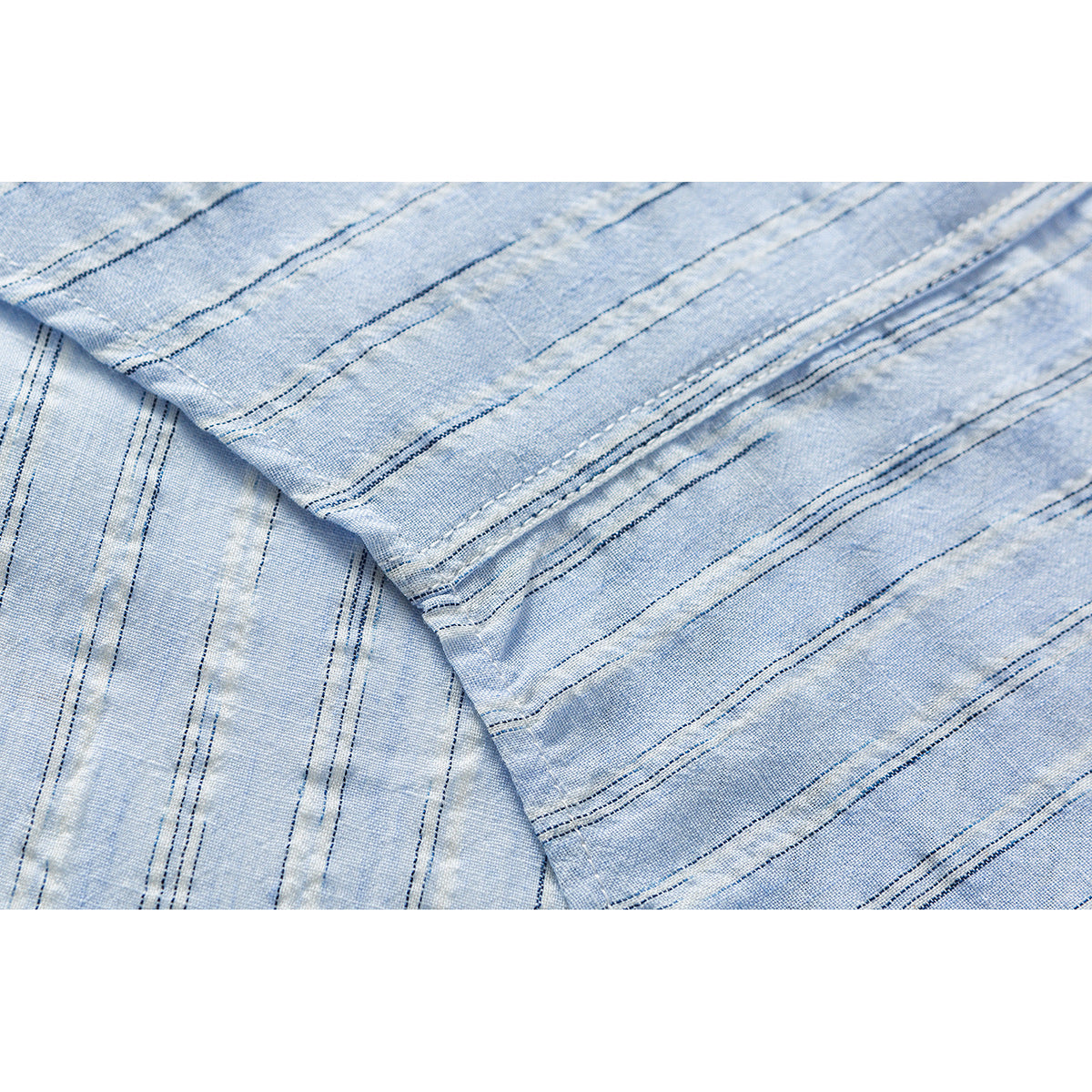 Close-up of light blue fabric with narrow dark stripes and visible stitching.