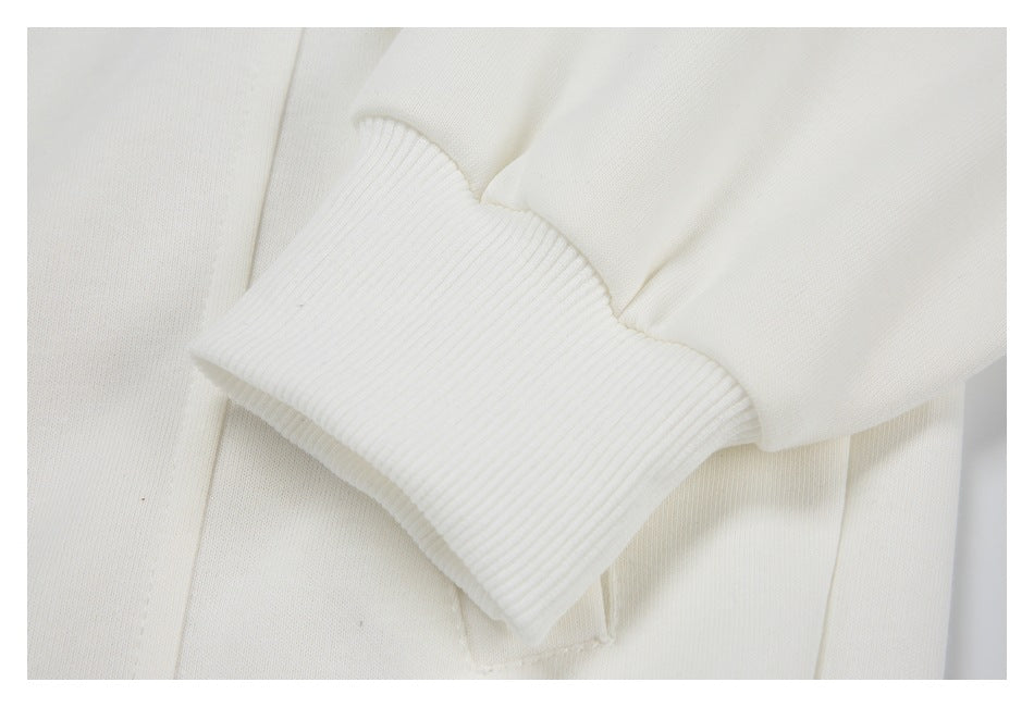Close-up of a ribbed white sleeve cuff and its seam against the garment body.