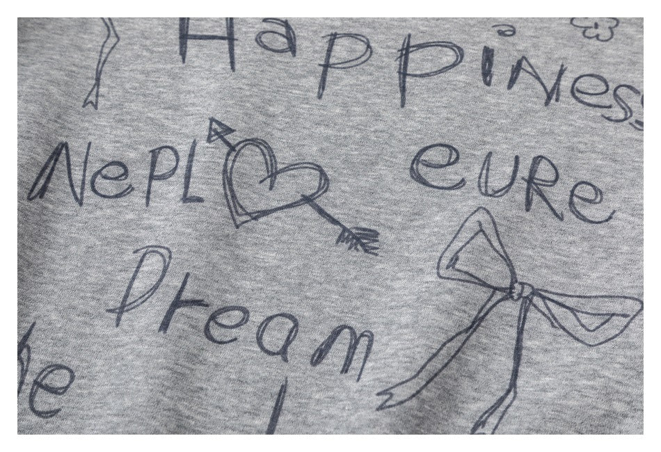Close-up of the sweatshirt's hand-drawn-style English lettering and bow and heart graphics on heather-gray fabric.