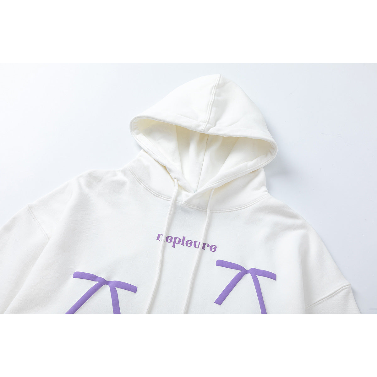 Cropped front view of a white pullover hoodie with drawstrings and purple lettering and bow-like graphics.
