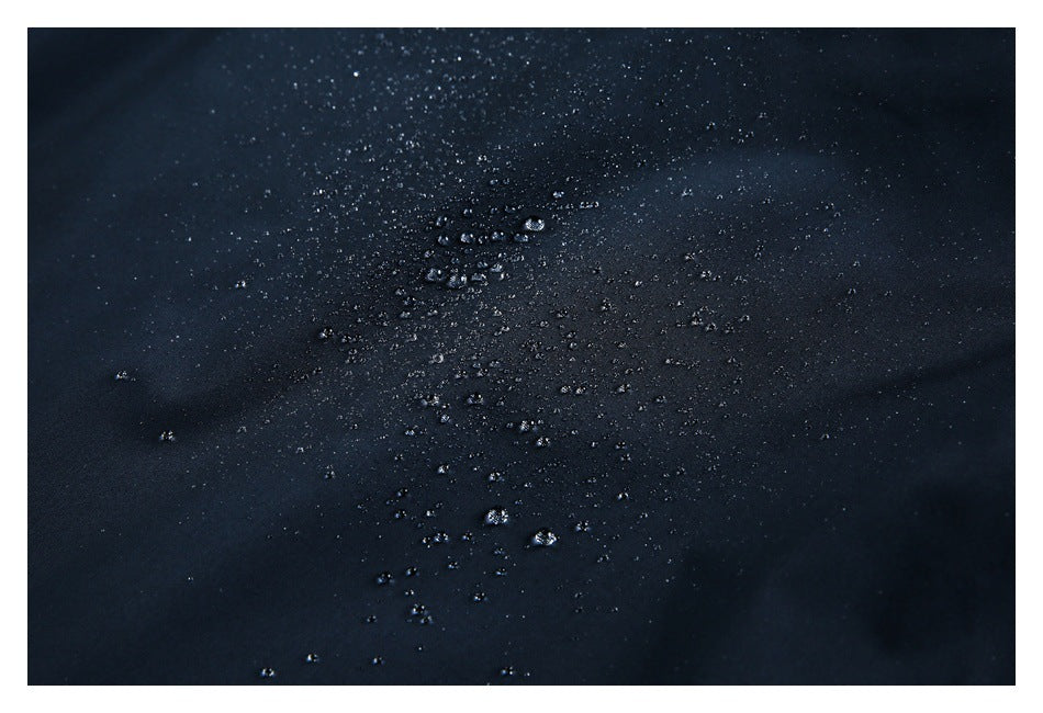 Water droplets bead on the surface of dark navy fabric.