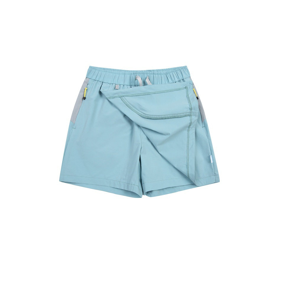 Light blue athletic shorts with an elastic drawstring waist, gray side panels, zip pockets, and a large flap pocket.