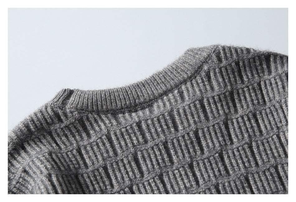 Close-up of a gray sweater's ribbed crew neckline and textured knit body.