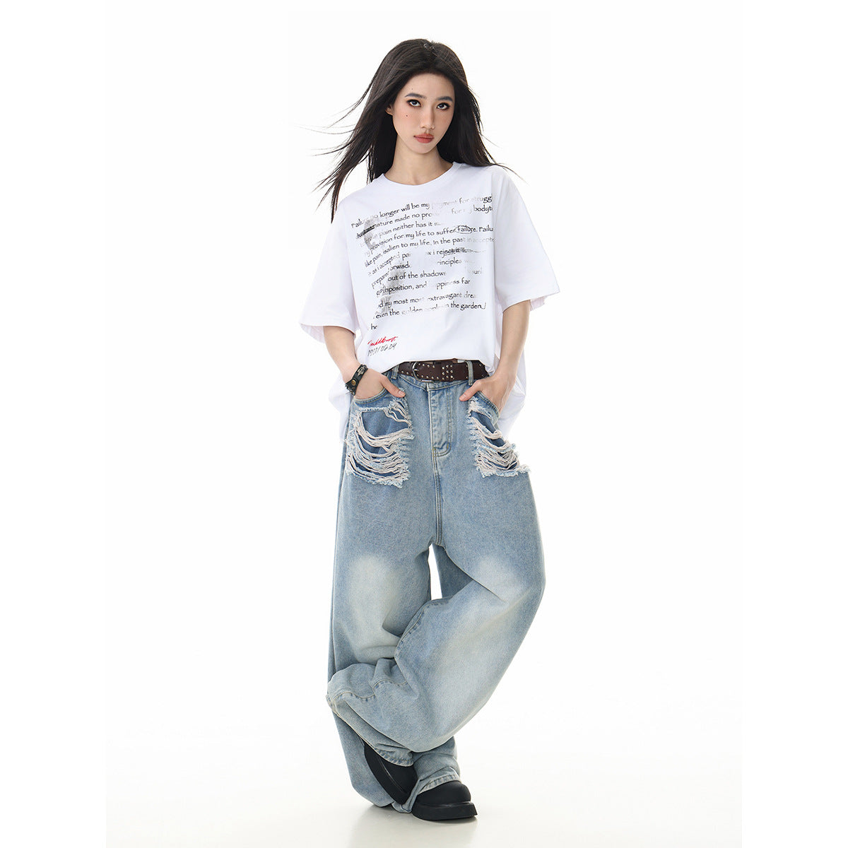 Model wearing an oversized white graphic T-shirt with light blue distressed wide-leg jeans, shown from the front.
