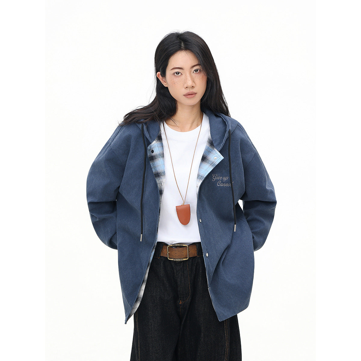Model wearing an open navy hooded jacket with plaid lining and small embroidered script on the chest.