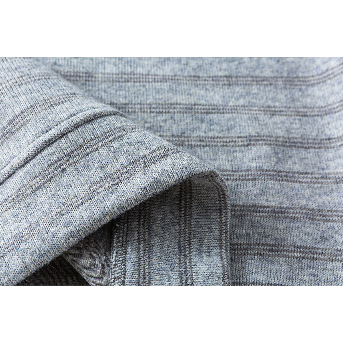 Close-up of the light gray knit pullover's folded fabric edge and interior stitching.